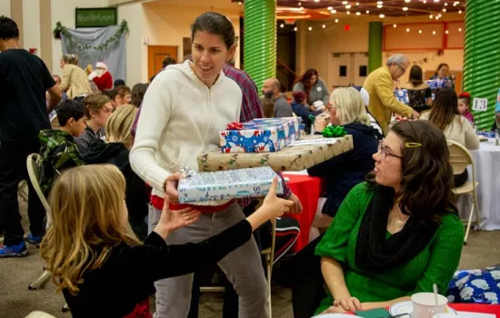 photo of a woman giving gifts at a christmas event
