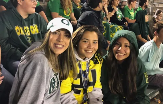 faith alongside a couple teenage girls at a football game